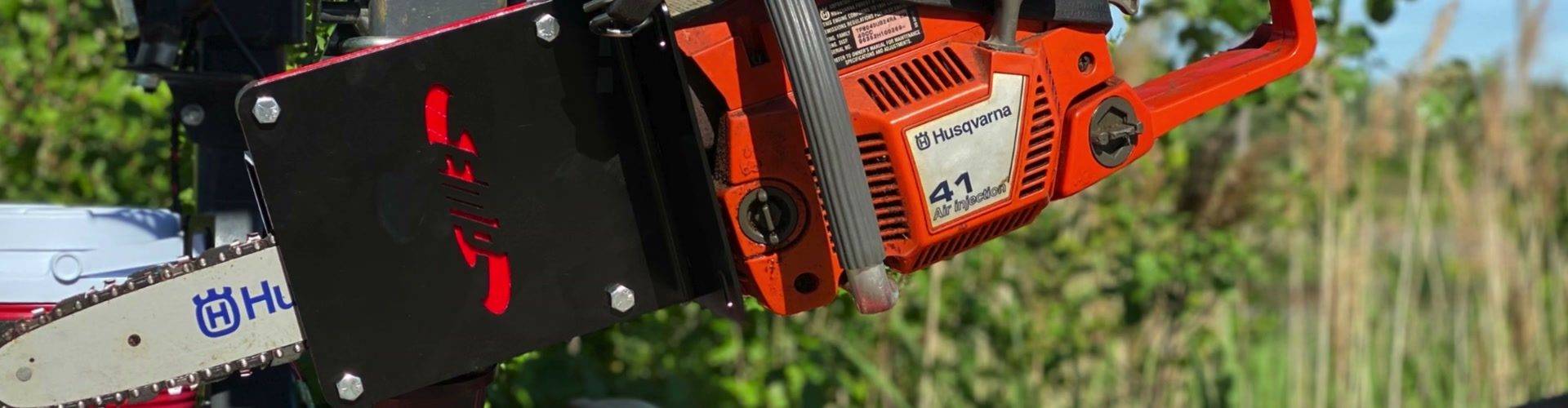 Husqvarna chainsaw held in an EMP chainsaw mount on a tractor